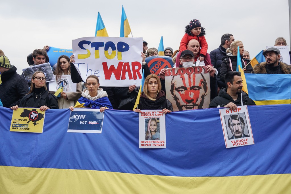 Manifestantes levantam faixas e bandeiras da Ucrânia durante uma manifestação contra a agressão russa em Istambul.