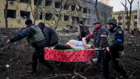 Equipe de emergência ucraniana e voluntários carregam uma mulher grávida ferida de uma maternidade danificada pelo bombardeio em Mariupol, Ucrânia, quarta-feira, 9 de março de 2022. 