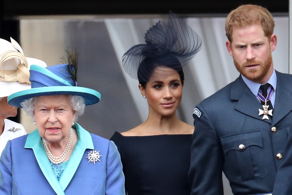 Rainha Elizabeth II, Príncipe Harry, Duque de Sussex e Meghan, Duquesa de Sussex na varanda do Palácio de Buckingham enquanto a família real participa de eventos para comemorar o centenário da RAF em 10 de julho de 2018 em Londres, Inglaterra. 