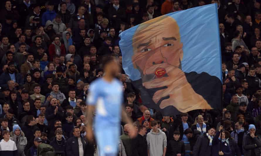 Torcedores do Manchester City levantam a bandeira do técnico Pep Guardiola.