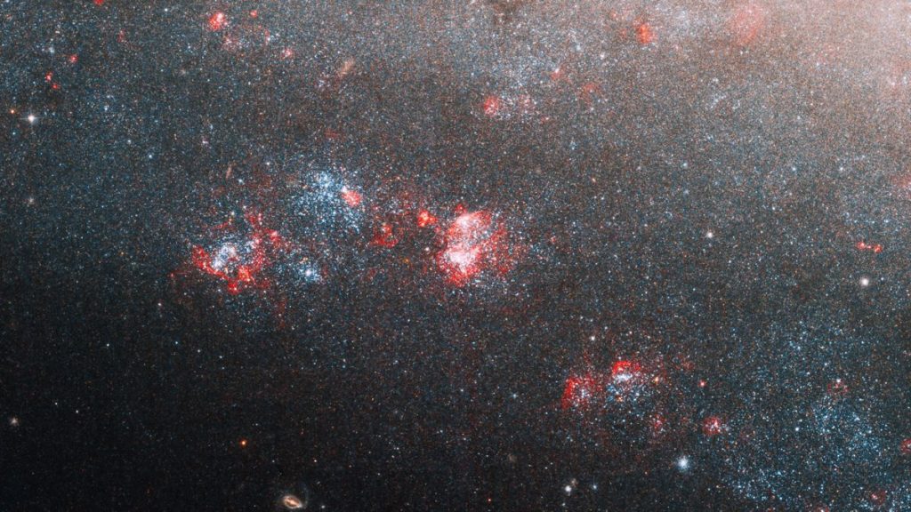 O Telescópio Hubble olha profundamente no buraco da agulha nesta imagem da galáxia espiral anã