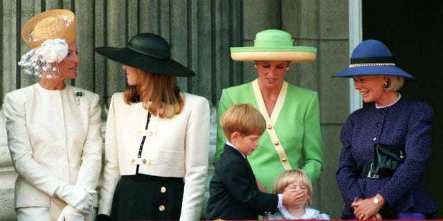 O príncipe Harry, em seu sexto aniversário, coloca a mão na boca da princesa Beatrice, de dois anos, enquanto ela se junta à princesa de Gales e outros membros da família real para assistir ao desfile do 50º aniversário da Batalha da Grã-Bretanha. manhã. 