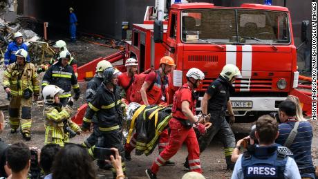 Equipes de resgate evacuam uma pessoa de um prédio de apartamentos destruído em um ataque aéreo russo no distrito de Shevchenkivsky, em Kyiv, em 26 de junho de 2022.