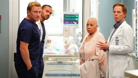 Dennis Dawes como Lauren Sims em Grey's Anatomy'  ao lado de Kevin McKidd como Dr. Owen Hunt, Jesse Williams como Dr. Jackson Avery e Greg German como Dr. Thomas Korasek.