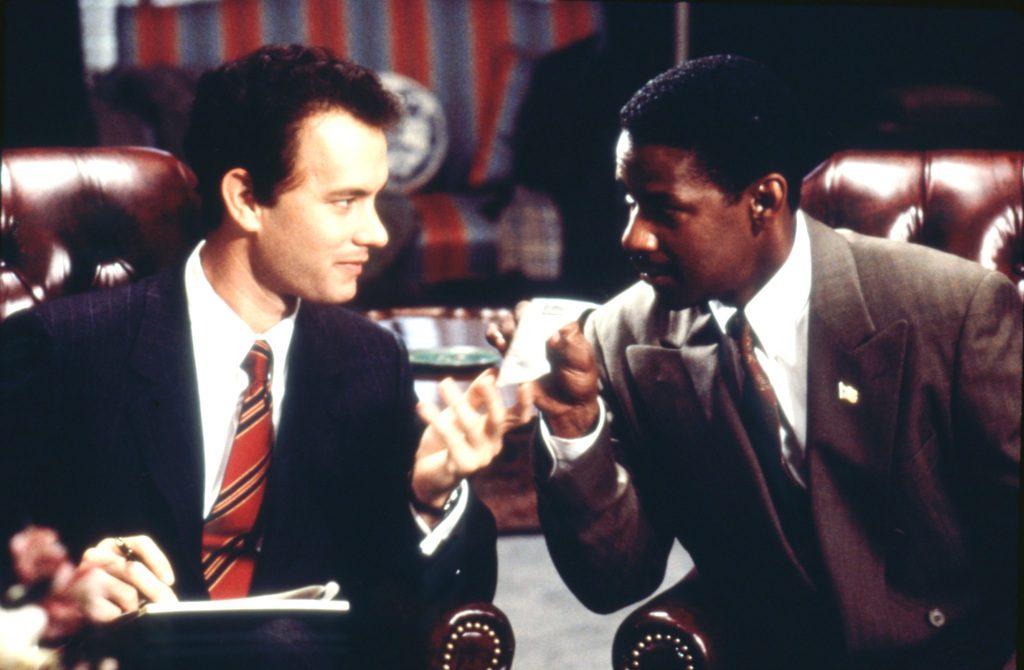 Tom Hanks e Denzel Washington sentados em um banco no filme de 1993, "Filadélfia"