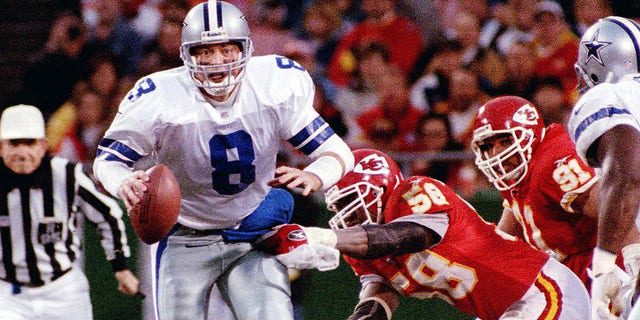 O quarterback do Dallas Cowboys, Troy Aikman, está prestes a ser demitido pelo quarterback do Kansas City Chiefs, Derek Thomas (à direita) em Kansas City.