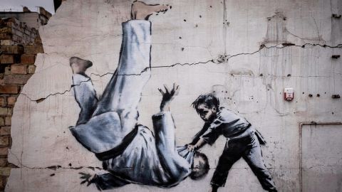 Um mural que Banksy não reivindicou oficialmente mostra um homem se virando durante uma luta de judô com um menino. 